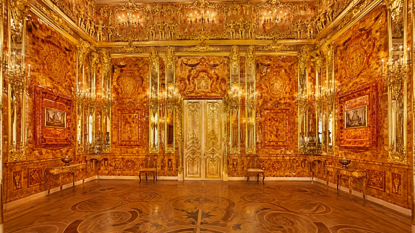 Opulent 18th-century chamber paneled entirely in glowing carved amber with gold and mirrored accents