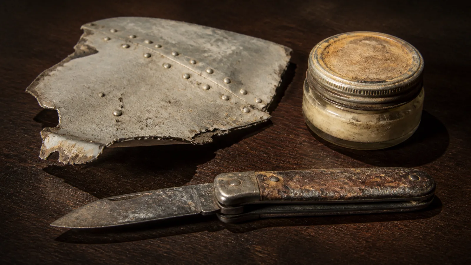Still-life arrangement of artifacts said to be recovered from Nikumaroro, including a pocketknife and aluminum panel fragment